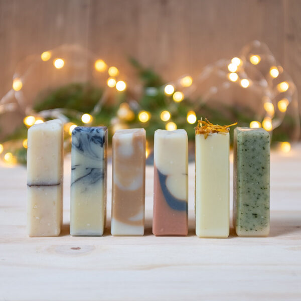 lot découverte mini format : 6 bâtonnets de savon de 30g, tous différents ; ambiance de Noël en fond